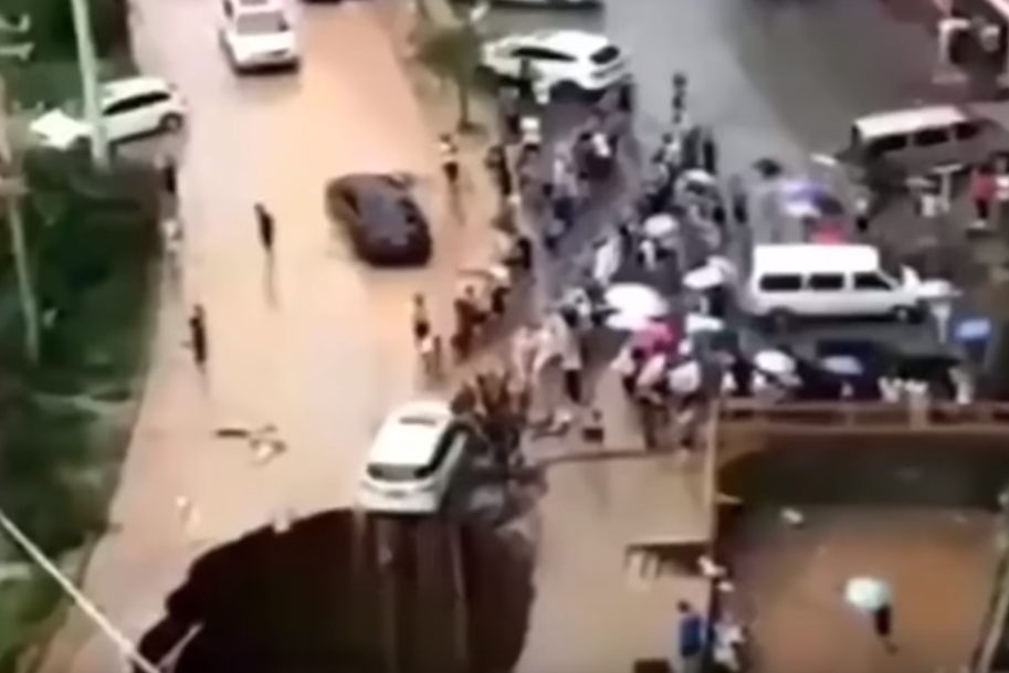 싱크홀에 뒷바퀴가 걸쳐져 추락 위기에 놓인 자동차