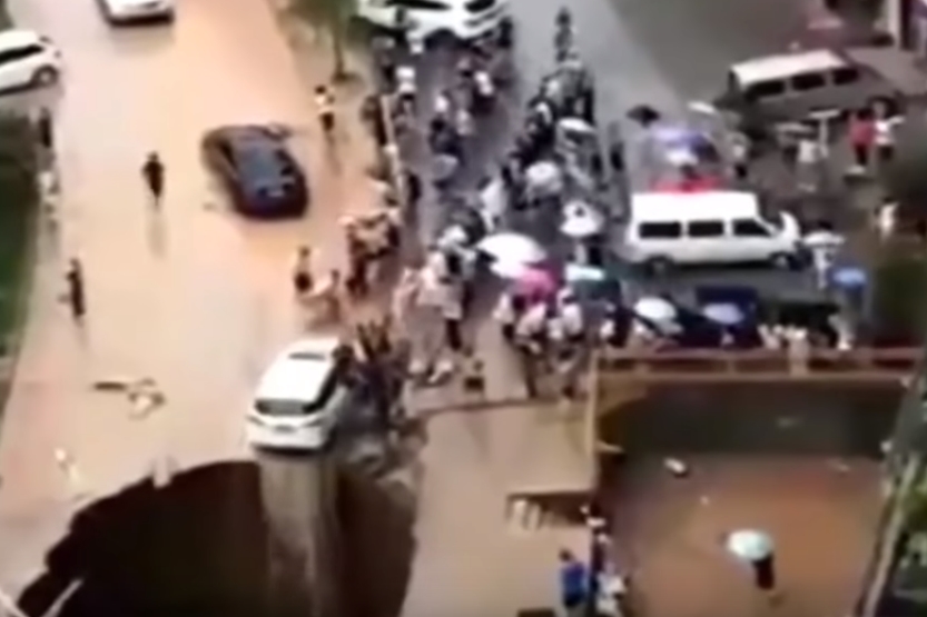 싱크홀에 뒷바퀴가 걸쳐져 추락 위기에 놓인 자동차