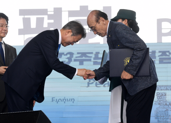 문재인 대통령이 15일 서울 용산구 국립중앙박물관 열린마당에서 열린 제73주년 광복절 및 정부수립 70주년 경축식에서  고 최병국 선생에게 건국훈장 애국장을 추서해 후손에게 친수 하고 있다.  2018.08.15 청와대사진기자단.