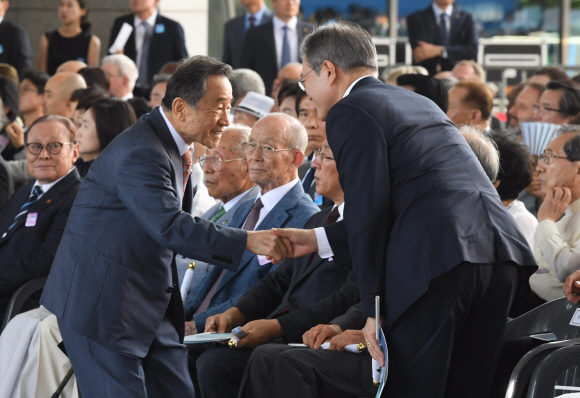 문재인 대통령이 15일 서울 용산구 국립중앙박물관 열린마당에서 열린 제73주년 광복절 및 정부수립 70주년 경축식에서 기념사를 마친 박유철 광복회장과 악수 하고 있다. 2018.08.15 청와대사진기자단.