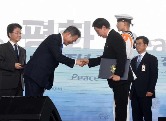 문재인 대통령이 15일 서울 용산구 국립중앙박물관 열린마당에서 열린 제73주년 광복절 및 정부수립 70주년 경축식에서  고 신창희 선생에게 건국포장 을 추서해 후손에게 친수 하고 있다.  2018.08.15 청와대사진기자단.