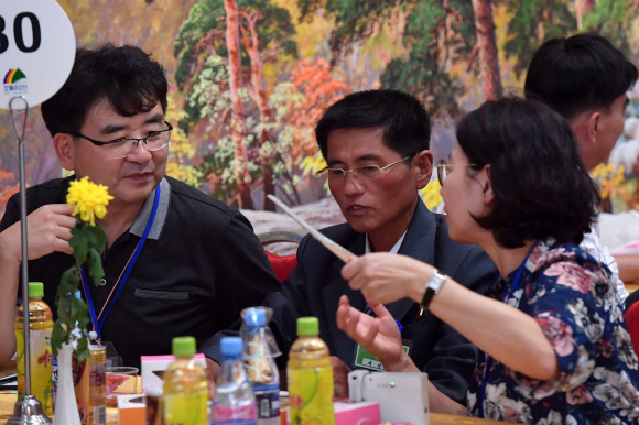 제21차 남북 이산가족 상봉 행사 이틀째인 21일 금강산호텔에서 열린 단체 상봉 행사에서 남측 민병현(82)씨의 북측 조카 채정렬(51)씨가 가족과 담소를 나누고 있다. 2018. 8. 21 사진공동취재단