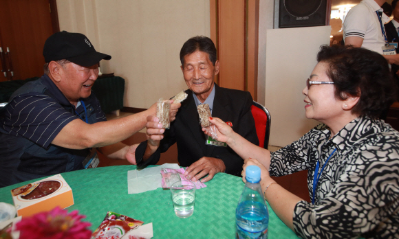 제21차 이산가족 상봉행사 1회차 둘째 날인 21일 오후 고성 금강산호텔에서 열린 단체상봉에 남측 함성찬(93) 할아버지가 동생 함동찬(7) 할아버지와 함께 과자를 나눠먹고 있다. 2018. 8. 21 사진공동취재단