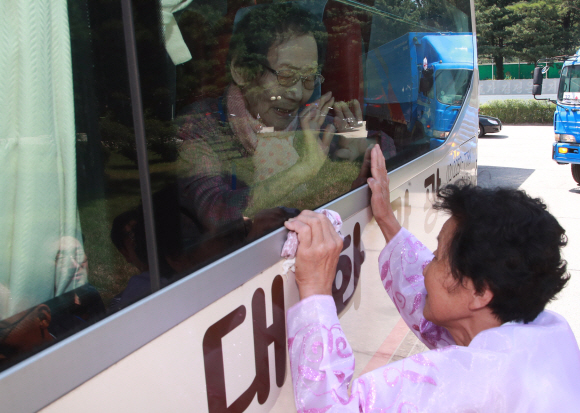 22일 강원도 고성 금강산호텔에서 열린 제21차 이산가족 상봉행사 작별상봉을 마친 한신자(88) 할머니가 버스에 올라타 북측에서 온 딸 김경영(71) 할머니에게 손을 흔들며 작별인사하고 있다. 2018. 8. 22 사진공동취재단