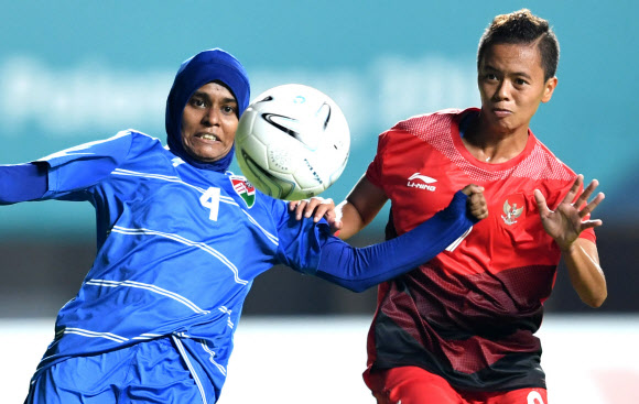 몰디브 여자축구 대표팀의 마힌 아이스하스(왼쪽)가 지난 16일 인도네시아와의 A조 1차전에서 상대 선수와 공을 다투고 있는 모습. 팔렘방 신화 연합뉴스