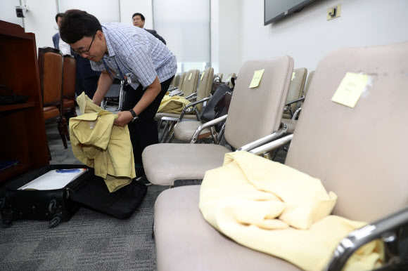 23일 오전 국회 본청 교육위원회 회의실에서 정부 관계자가 태풍 북상에 따라 만일의 사태를 대비해 회의에 참석하는 공무원들의 민방위복을 준비하고 있다. 2018.8.23  연합뉴스