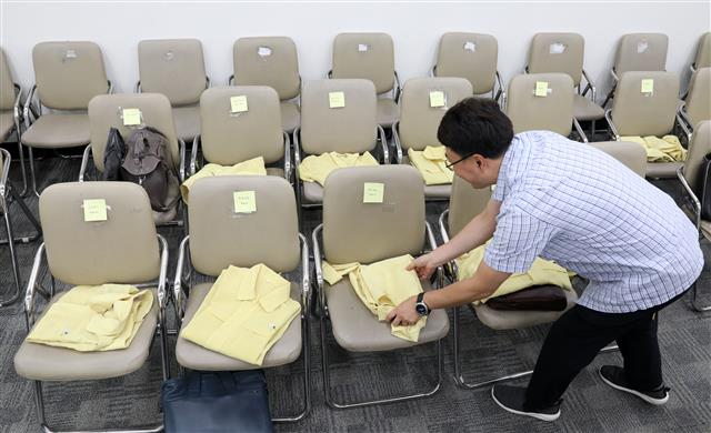 23일 오전 서울 여의도 국회 교육위원회 전체회의장에서 교육부 관계자가 국무위원 및 관계자 배석 자리에 민방위복을 준비하고 있다. 2018.8.23 뉴스1