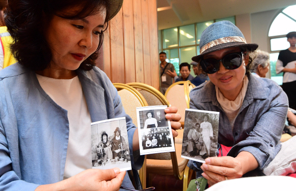 제21차 남북 이산가족 상봉행사 등록날인 23일 강원도 속초 한화리조트에서 이진희(58·왼쪽)씨와 이소희(63)씨가 북측 고모 리선례(81)씨에게 보여줄 가족사진을 정리하고 있다. 2018. 8. 23  사진공동취재단