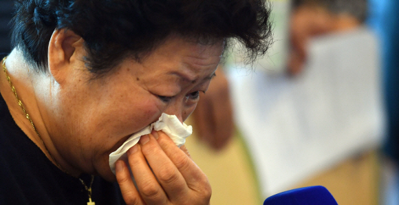 8.15 계기 ‘제21차 이산가족 상봉행사’(2회차)를 하루 앞둔 23일 오후 강원도 속초시 한화리조트 설악에 도착한 한 상봉 대상자가 상봉 등록을 하며 눈물 흘리고 있다. 이번 상봉 행사에 참여한 남북 상봉단은 24일부터 사흘간 6차례, 총 12시간 상봉한다. 2018. 8. 23  사진공동취재단