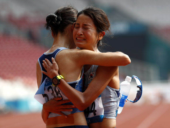 여자마라톤 6위를 차지한 김도연(오른쪽)이 먼저 4위로 결승선을 통과한 최경선의 품에 안겨 울음을 터뜨리고 있다. 자카르타 AP 연합뉴스