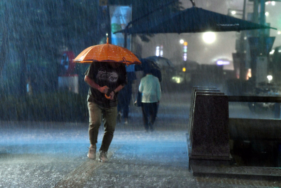 서울지역에 호우경보가 발효된 28일 밤 서울 시내를 한 시민 비바람을 맞으며 걸어가고 있다. 2018.8.28안주영 기자 jya@seoul.co.kr