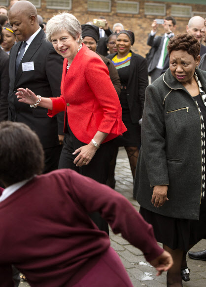 28일(현지시간) 남아프리카공화국 케이프타운의 한 고교를 방문한 테리사 메이 영국 총리가 건들건들 춤추는 모습. AP 연합뉴스