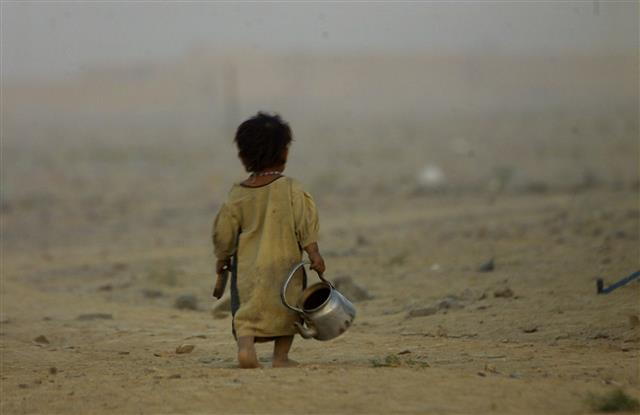 5년여에 걸친 아프가니스탄 내전이 끝난 직후인 2001년 10월 첫 추위가 엄습한 가운데 한 어린이가 주전자를 들고 물을 길으려 아프가니스탄과 파키스탄 국경의 황무지를 걸어가고 있다. AP 연합뉴스
