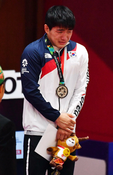 30일 인도네시아 자카르타 컨벤션센터에서 열린 자카르타·팔레방아시안게임 유도 남자 73kg급 시상식에서 은메달을 획득한 한국의 안창림이 시상대에서 눈물을 흘리고 있다.  자카르타 박윤슬 기자 seul@seoul.co.kr