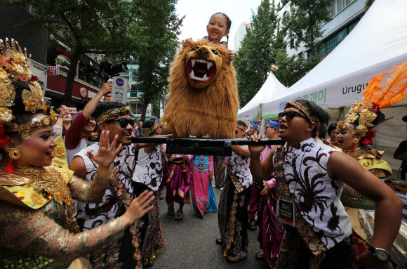 1일 서울광장과 무교로 일대에서 열린 2018 서울세계도시문화축제에서 각국 전통 의상을 입은 출연자들이 세계거리퍼레이드를 하는 중 한 어린이를 가마에 태운 채 흥겨운 춤을 추고 있다. 2018.9.1 연합뉴스