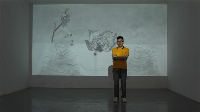 중국 베이징의 대안 공간 ‘드 아트센터’를 연 큐레이터 샤옌궈가 한국 작가 이승애의 작품 앞에 서 있다.