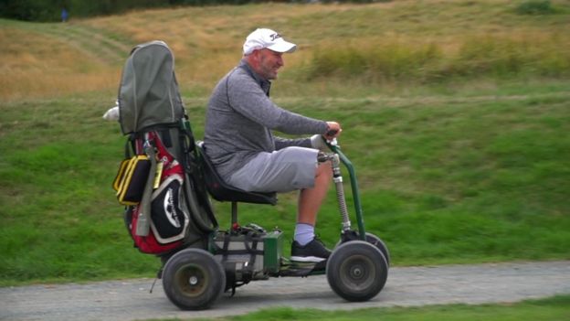 전동 카트를 몰며 골프 경기를 즐기는 폴 휴턴.