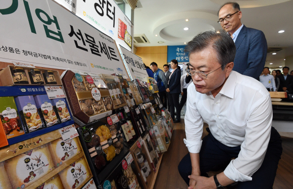 11일 청와대 연풍문에서 열린 추석맞이 직거래장터를 찾은 문재인 대통령이 선물를 꼼꼼히 살피고 있다. 2018. 9. 11 도준석 기자 pado@seoul.co.kr