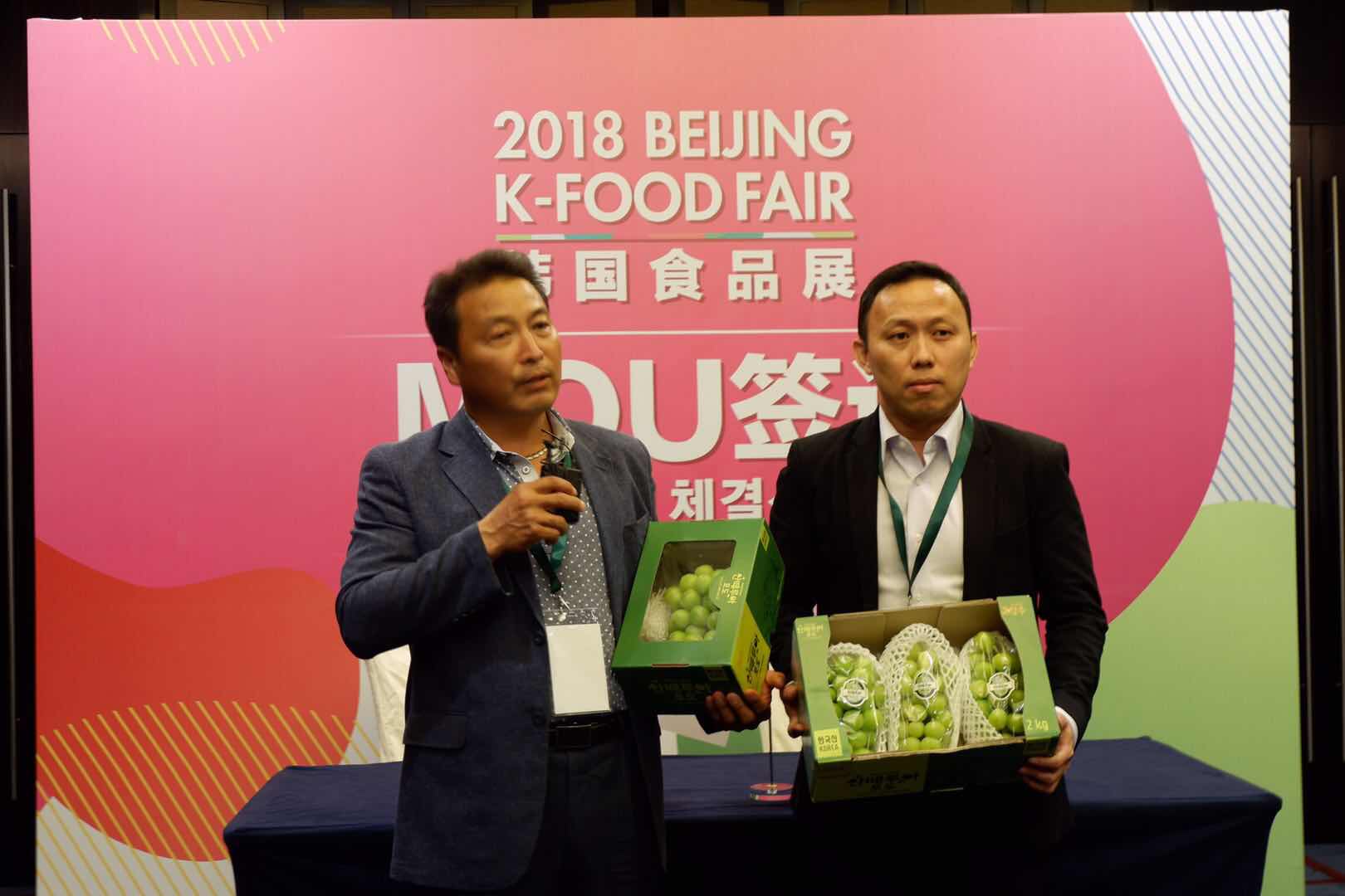 한국 샤인머스켓 포도 생산자가 13일 중국 베이징에서 열린 ‘2018 베이징 K-푸드 페어’에서 200만 달러 대중국 수출 계약을 맺고 있다. aT제공