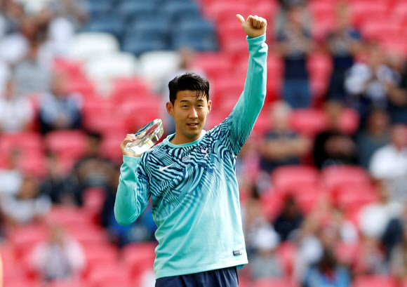 잉글랜드 프리미어리그 토트넘에서 활약하는 손흥민이 15일 리버풀과의 경기 직전에 소속팀이 아시안게임 금메달을 축하하는 특별 트로피를 받고 손을 들어 인사하고 있다. 로이터 연합뉴스