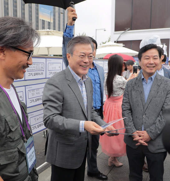 문재인 대통령이 16일 오후 광화문 광장에서 열리는 실패 박람회를 노숙인 출신 사진작가들과 찍은 기념사진을 받고 있다. 2018. 9. 16. 도준석기자 pado@seoul.co.kr