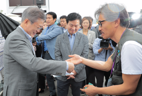 문재인 대통령이 16일 오후 광화문 광장에서 열리는 실패 박람회를 노숙인 출신 사진작가들과 찍은 기념사진을 받고 있다. 2018. 9. 16. 도준석기자 pado@seoul.co.kr