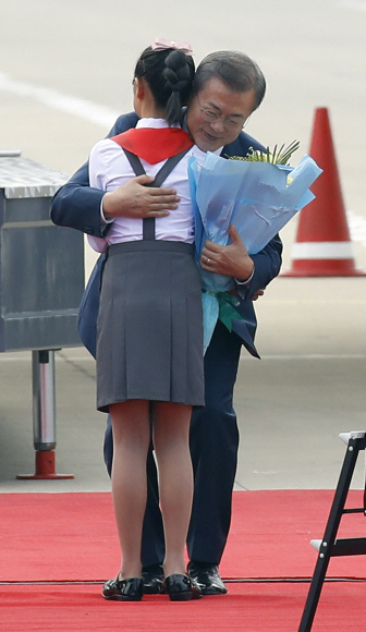 문재인 대통령이 18일 오전 평양 순안공항 도착해 화동에게 꽃다발을 받은 뒤 포옹하고 있다. 2018.9.18 평양사진공동취재단
