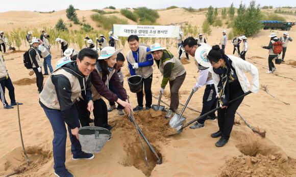 18일  중국 네이멍구(內蒙古)쿠부치 사막의 조림지’대한항공 생태원’에서 황사방지를 위한 나무심기 봉사 활동에 참여한 대한항공 임직원들과 중국 현지 관계자들이 나무를 심고 물을 주며 즐거워 하고 있다. 2018. 9. 18 쿠부치=안주영 기자 jya@seoul.co.kr