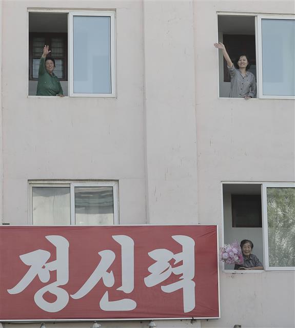 건물 안에 있던 평양시민이 창문 밖으로 손을 내밀어 이동 중인 문재인 대통령을 환영하고 있다.  평양사진공동취재단
