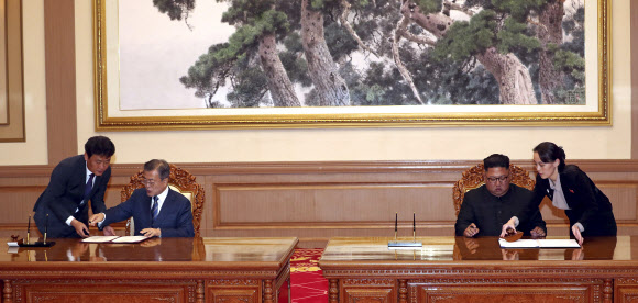 문재인 대통령과 김정은 국무위원장이 19일 백화원 영빈관에서 정상회담을 마친 뒤 평양공동선언서에 서명하고 있다. AP 연합뉴스
