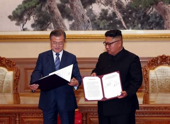 문재인 대통령과 김정은 국무위원장이 19일 백화원 영빈관에서 정상회담을 마친 뒤 평양공동선언서에 서명한 뒤 교환하고 있다. 2018.9.19 /평양사진공동취재단