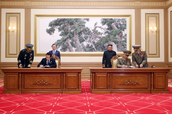 문재인 대통령과 김정은 국무위원장이 19일 백화원 영빈관에서 송영무 국방부 장관과 노광철 인민무력상의 판문점선언 이행을 위한 군사분야 합의문을 서명을 지켜보고 있다. 2018.9.19 /평양사진공동취재단