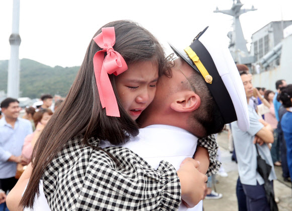 20일 오전 경남 창원시 진해구 진해군항에서 열린 청해부대 26진 문무대왕함 입항환영식에서 부사관이 딸을 안고 있다.  이번에 입항한 청해부대 26진은 120여일간 소말리아, 가나, 리비아 등에서 작전을 펼쳤다. 2018.9.20  연합뉴스