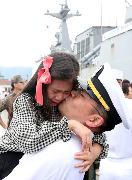 20일 오전 경남 창원시 진해구 진해군항에서 열린 청해부대 26진 문무대왕함 입항환영식에서 부사관이 딸을 안고 있다.  이번에 입항한 청해부대 26진은 120여일간 소말리아, 가나, 리비아 등에서 작전을 펼쳤다. 2018.9.20  연합뉴스