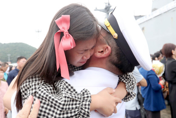 20일 오전 경남 창원시 진해구 진해군항에서 열린 청해부대 26진 문무대왕함 입항환영식에서 부사관이 딸을 안고 있다.  이번에 입항한 청해부대 26진은 120여일간 소말리아, 가나, 리비아 등에서 작전을 펼쳤다. 2018.9.20  연합뉴스