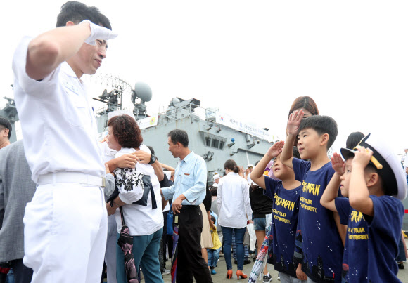 20일 오전 경남 창원시 진해구 진해군항에서 열린 청해부대 26진 문무대왕함 입항환영식에서 부사관이 아들과 거수경례하고 있다.  이번에 입항한 청해부대 26진은 120여일간 소말리아, 가나, 리비아 등에서 작전을 펼쳤다. 2018.9.20  연합뉴스