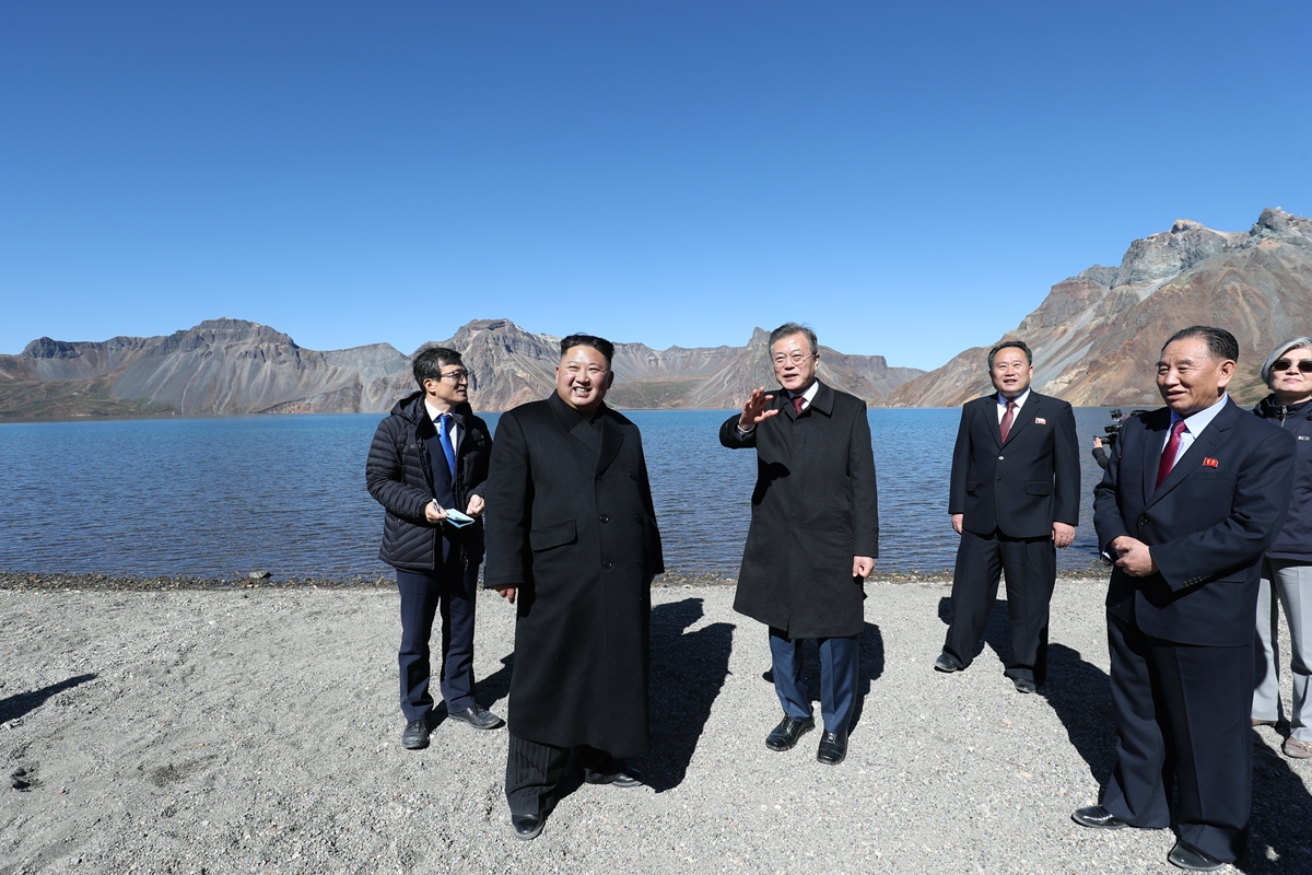 문재인 대통령(왼쪽 세 번째)과 김정은(두 번째) 북한 국무위원장이 20일 수행원들과 함께 백두산 정상에 올라 대화를 나누고 있다. 평양사진공동취재단