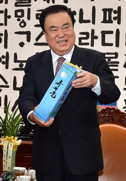 문희상 국회의장이 21일 제3차 남북정상회담 일정에 참여했던 당 대표들과 회동하며 정의당 이정미 대표로부터 북한 특산품 류경술을 받고 있다. 2018.9.21  연합뉴스