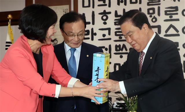 이정미 정의당 대표가 21일 서울 여의도 국회 국회의장실에서 열린 국회의장과 평양남북정상회담 특별수행한 3당 대표 회동에 앞서 문희상 국회의장에게 ‘류경술’을 선물하고 있다. 왼쪽 부터 이정미 정의당 대표, 이해찬 더불어민주당 대표, 문희상 의장. 2018.9.21 뉴스1