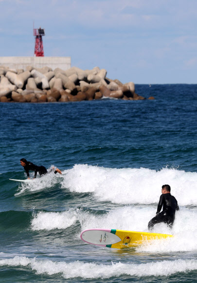 가을 바다 가르는 서퍼들