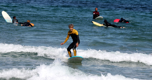 가을 바다 가르는 서퍼들