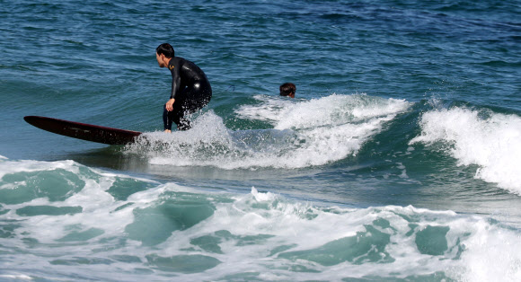 가을 바다 가르는 서퍼들