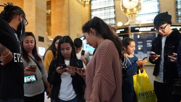 미국 뉴욕의 그랜드 센트럴 역에 있던 사람들이 3일 오후(현지시간) 일제히 발송된 테스트 경보 문자를 들여다보고 있다. 뉴욕 AFP 연합뉴스 