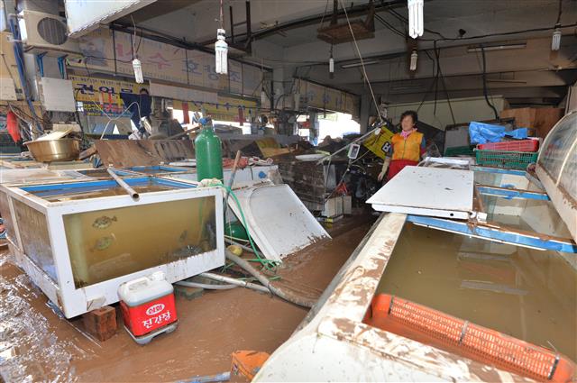 7일 태풍 콩레이가 쏟아부은 물폭탄에 침수 피해를 당한 경북 영덕군 강구면 강구전통시장에서 상인이 복구 작업에 엄두를 내지 못하고 있다. 2018.10.7 뉴스1