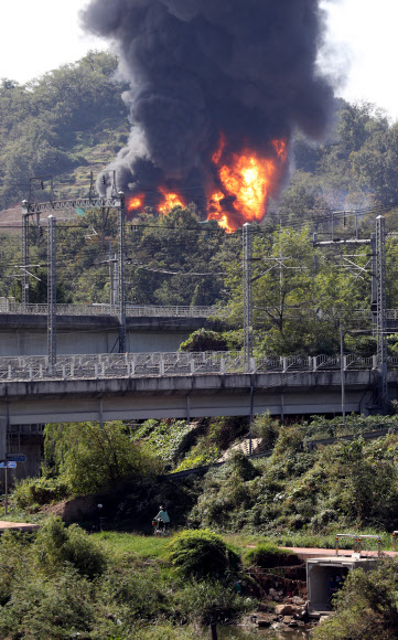 7일 경기도 고양시 덕양구 화전동 송유관공사 저유소에서 휘발유 탱크 폭발로 추정되는 큰불이 발생, 인근에서 시민 등이 자전거를 타고 있다. 2018.10.7  연합뉴스