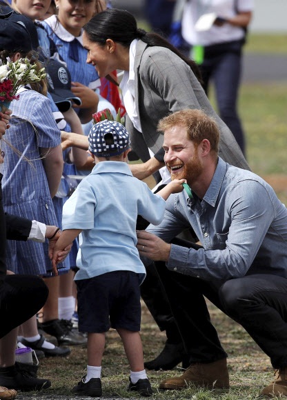 영국의 해리 왕자가 17일(현지시간) 호주 더보 두보지역 공항에 도착해 환영나온 부니용 공립학교의 학생을 안아주고 있다. AP 연합뉴스