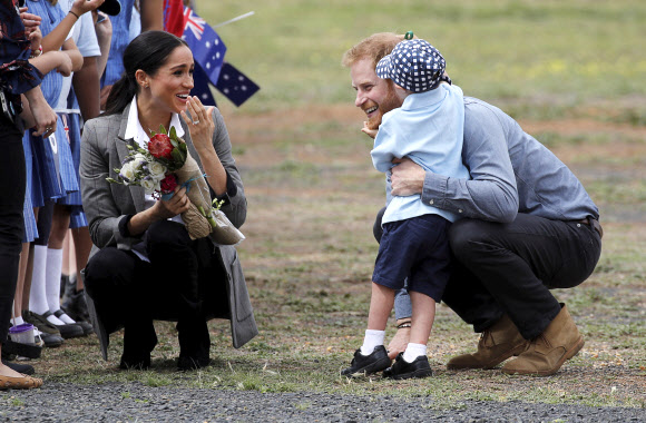 Britain‘s Prince Harry and Meghan, Duchess of Sussex are embraced by Luke Vincent, 5, on their arrival in Dubbo, Australia, Wednesday, Oct. 17, 2018. Prince Harry and his wife Meghan are on day two of their 16-day tour of Australia and the South Pacific. (Phil Noble/Pool via AP)/2018-10-17 09:47:32/ <연합뉴스