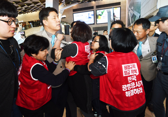 17일 김포공항 국내선 여객터미널이 10여 년에 걸친 리모델링 사업을 마치고 정식 개장식이 열리고 있는 3층 출국장에서 한국공항공사 비정규직 노조원들이 기습시위를 벌이다가 저지 당하고 있다 . 2018. 10. 17 안주영 기자 jya@seoul.co.kr