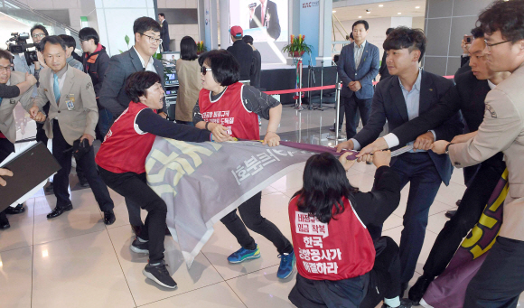 김포공항 국내선 여객터미널이 10여 년에 걸친 리모델링 사업을 마치고 정식 개장한 17일 개장축하 행사장에서 비정규직직원들이 정규직전환을 요구하며 사측과 몸싸움을 하고 있다. 2018. 10. 17 안주영 기자 jya@seoul.co.kr