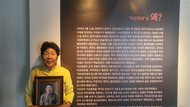 지난 15일 ‘여순항쟁 기록전’이 열린 전남 여수 노마드갤러리에서 여순사건으로 아버지와 시아버지를 잃은 장경자씨가 아버지의 사진을 들고 서 있다.